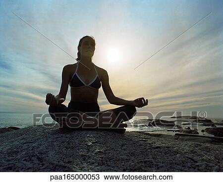 Woman sitting in lotus position, sky and seascape in background View Large Photo Image Stock Image - Woman sitting in lotus position, sky and seascape in background. Fotosearch