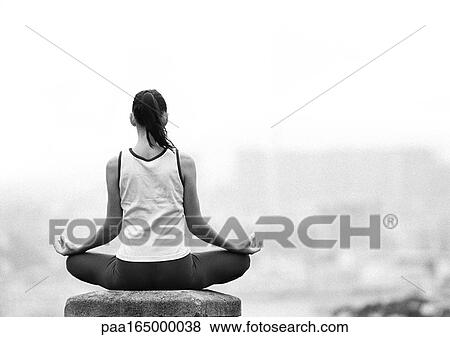 Woman sitting in yoga position, overlooking city, rear view, blurred, focus on foreground, b&w View Large Photo Image Stock Photo - Woman sitting in yoga position, overlooking city, rear view, blurred, focus on foreground, b&w. Fotosearch