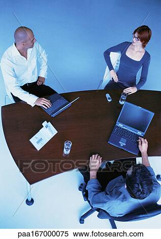 Business people around desk, elevated view View Large Photo Image Stock Photography - Business people around desk, elevated view. Fotosearch