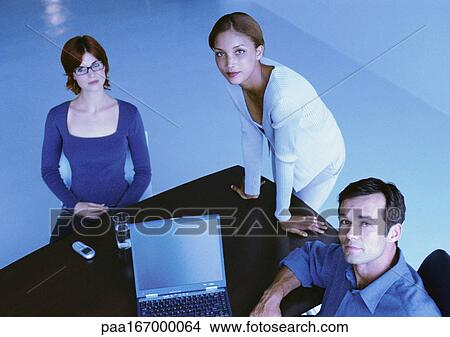 Picture - Business people around desk, smiling, elevated view. Fotosearch