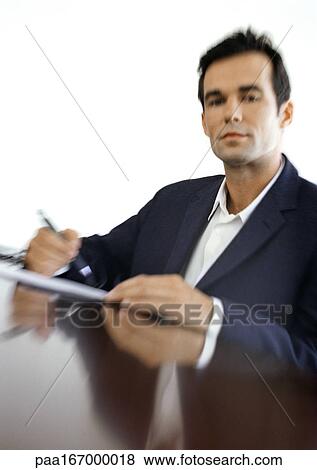 Stock Photo - Businessman sitting at desk, blurred, portrait. Fotosearch