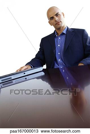 Businessman sitting at desk, portrait View Large Photo Image Stock Image - Businessman sitting at desk, portrait. Fotosearch