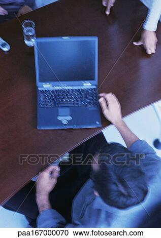 Businessman sitting at desk with laptop computer, elevated view View Large Photo Image Stock Image - Businessman sitting at desk with laptop computer, elevated view. Fotosearch