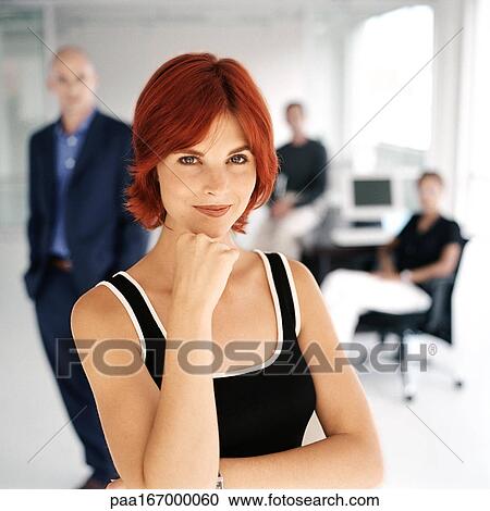 Businesspeople in office, focus on woman in foreground, portrait View Large Photo Image Stock Image - Businesspeople in office, focus on woman in foreground, portrait. Fotosearch