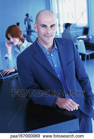 Businesspeople in office, man smiling at camera, portrait View Large Photo Image Stock Photo - Businesspeople in office, man smiling at camera, portrait. Fotosearch