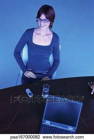 Businesswoman at desk, smiling, high angle view View Large Photo Image Stock Image - Businesswoman at desk, smiling, high angle view. Fotosearch