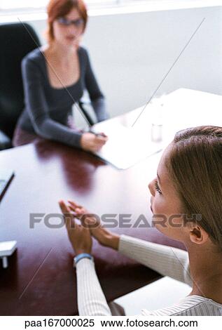 Businesswomen sitting at desk View Large Photo Image Stock Photography - Businesswomen sitting at desk. Fotosearch