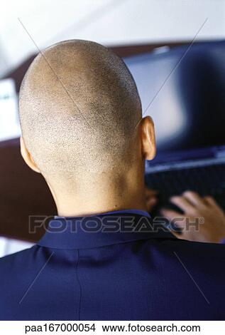 Picture - Man working on computer, rear view, close-up. Fotosearch