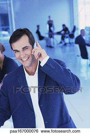 People in office, businessman using cell phone, smiling, portrait View Large Photo Image Stock Photograph - People in office, businessman using cell phone, smiling, portrait. Fotosearch