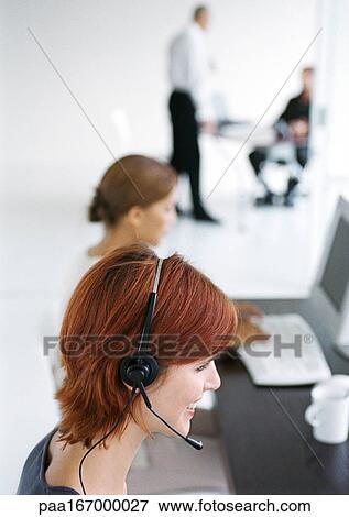 Woman in office, wearing headset, blurred View Large Photo Image Stock Photo - Woman in office, wearing headset, blurred. Fotosearch