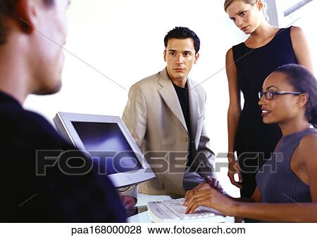 Business people around computer View Large Photo Image Stock Photo - Business people around computer. Fotosearch