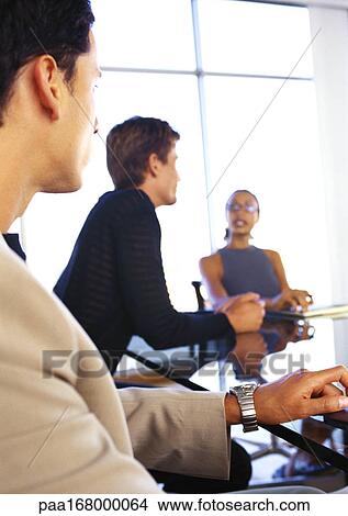 Business people sitting at table, blurred View Large Photo Image Picture - Business people sitting at table, blurred. Fotosearch