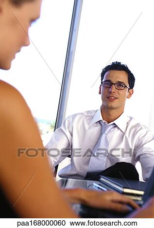 Businessman and woman, sitting at desk, portrait View Large Photo Image Stock Image - Businessman and woman, sitting at desk, portrait. Fotosearch