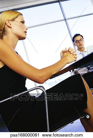Businessman and woman sitting in office, low angle view View Large Photo Image Stock Image - Businessman and woman sitting in office, low angle view. Fotosearch