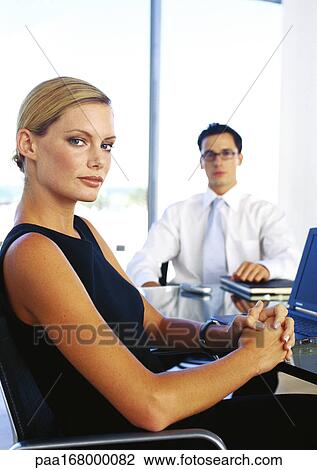 Businessman and woman sitting in office, portrait View Large Photo Image Stock Image - Businessman and woman sitting in office, portrait. Fotosearch