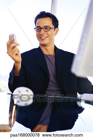 Businessman holding cell phone, smiling View Large Photo Image Stock Photo - Businessman holding cell phone, smiling. Fotosearch