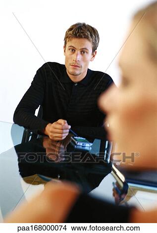 Businessman using pocket computer, blurred profile of woman in foreground View Large Photo Image Picture - Businessman using pocket computer, blurred profile of woman in foreground. Fotosearch