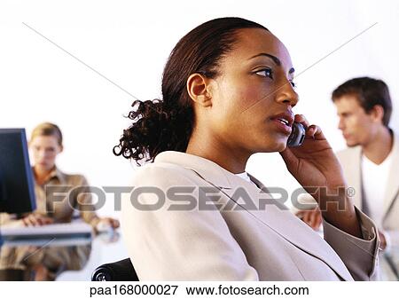 Businesspeople in office, woman using cell phone, side view View Large Photo Image Stock Photo - Businesspeople in office, woman using cell phone, side view. Fotosearch
