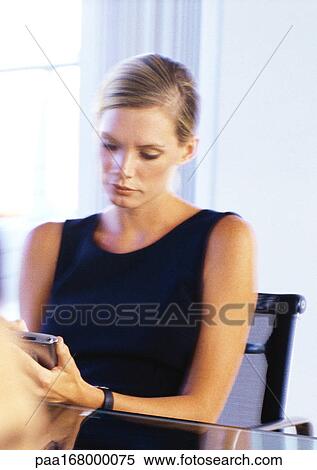 Businesswoman looking at pocket computer View Large Photo Image Stock Photography - Businesswoman looking at pocket computer. Fotosearch
