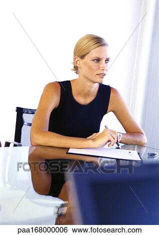 Businesswoman sitting at desk View Large Photo Image Stock Photograph - Businesswoman sitting at desk. Fotosearch