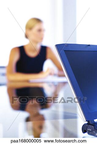 Businesswoman sitting at desk View Large Photo Image Stock Photography - Businesswoman sitting at desk. Fotosearch