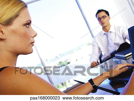 Businesswoman sitting at desk with businessman, side view, close-up View Large Photo Image Stock Image - Businesswoman sitting at desk with businessman, side view, close-up. Fotosearch