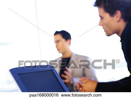 Two men, one with laptop computer, blurred View Large Photo Image Stock Photograph - Two men, one with laptop computer, blurred. Fotosearch