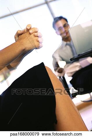 Woman's clasped hands and knee, man sitting in background View Large Photo Image Stock Photo - Woman's clasped hands and knee, man sitting in background. Fotosearch
