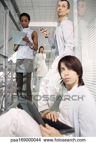 Business people working in office hallway View Large Photo Image Picture - Business people working in office hallway. Fotosearch