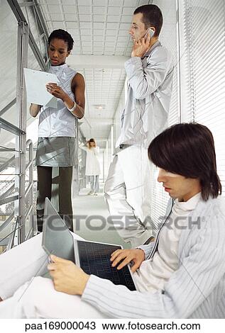 Business people working in office hallway View Large Photo Image Stock Image - Business people working in office hallway. Fotosearch