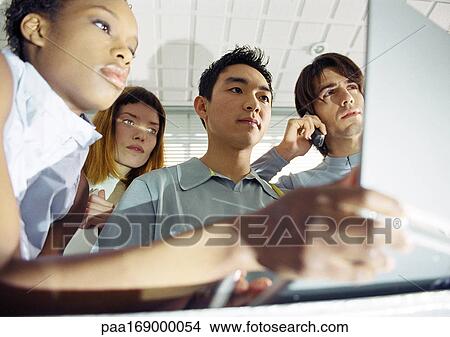 Four young people, one holding laptop, low angle view View Large Photo Image Picture - Four young people, one holding laptop, low angle view. Fotosearch