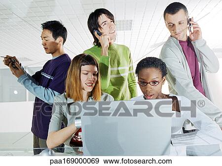 Group of people gathered around computer View Large Photo Image Stock Photo - Group of people gathered around computer. Fotosearch