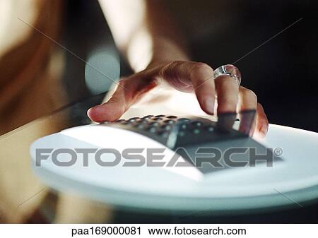 Stock Image - Hand on calculator, close-up. Fotosearch