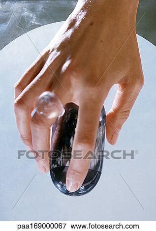 Stock Photo - Hand on cordless mouse, elevated view. Fotosearch