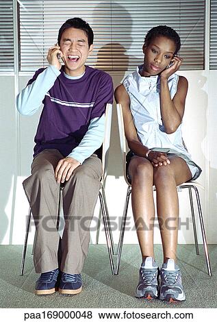 Man and woman in seats using cell phones View Large Photo Image Stock Photo - Man and woman in seats using cell phones. Fotosearch