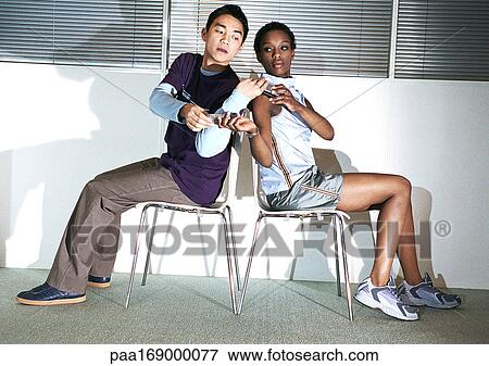 Man and woman sitting back to back, exchanging cell phones View Large Photo Image Stock Photo - Man and woman sitting back to back, exchanging cell phones. Fotosearch