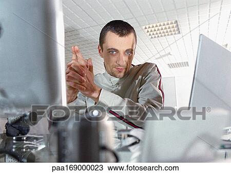 Man at desk looking into camera, portrait View Large Photo Image Stock Image - Man at desk looking into camera, portrait. Fotosearch