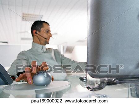 Man at desk using cordless mouse View Large Photo Image Stock Image - Man at desk using cordless mouse. Fotosearch