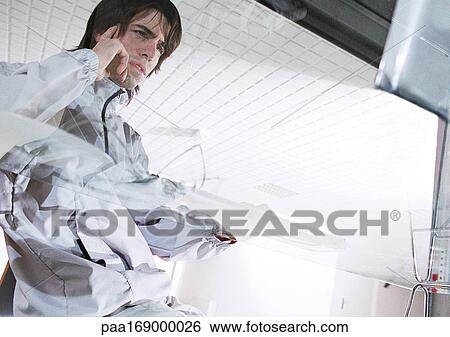 Man sitting at glass desk View Large Photo Image Stock Photograph - Man sitting at glass desk. Fotosearch