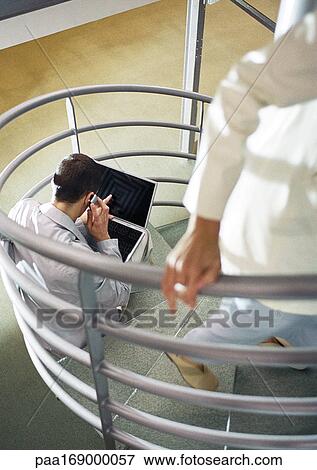 Man sitting on stairs, woman coming up stairs, high angle view View Large Photo Image Stock Photo - Man sitting on stairs, woman coming up stairs, high angle view. Fotosearch
