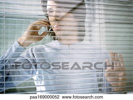 Man with cell phone leaning against window View Large Photo Image Stock Image - Man with cell phone leaning against window. Fotosearch