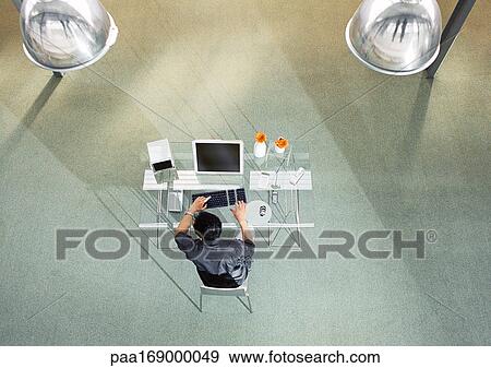 Man working on computer, elevated view View Large Photo Image Stock Photo - Man working on computer, elevated view. Fotosearch