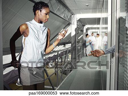 People in hallway, woman using cell phone, man's hand reaching toward her View Large Photo Image Stock Image - People in hallway, woman using cell phone, man's hand reaching toward her. Fotosearch