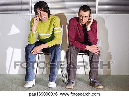 Two men in seats with cell phones View Large Photo Image Stock Photograph - Two men in seats with cell phones. Fotosearch