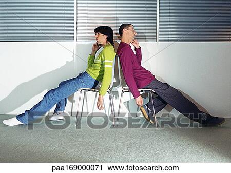 Two men sitting back to back in chairs View Large Photo Image Stock Image - Two men sitting back to back in chairs. Fotosearch
