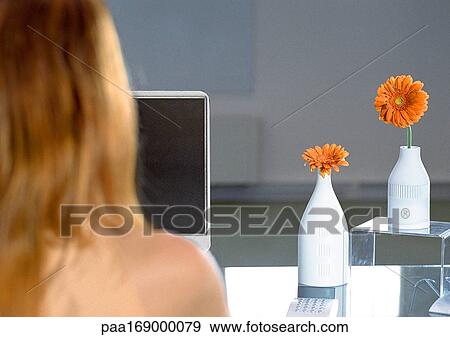 Woman at desk with orange flowers, rear view View Large Photo Image Stock Photo - Woman at desk with orange flowers, rear view. Fotosearch