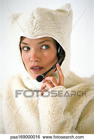 Woman wearing fleecy hooded sweater, using headset View Large Photo Image Stock Photograph - Woman wearing fleecy hooded sweater, using headset. Fotosearch