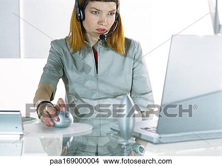 Woman wearing headset using computer View Large Photo Image Picture - Woman wearing headset using computer. Fotosearch