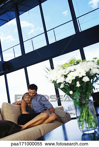 Couple cuddling on sofa View Large Photo Image Stock Photography - Couple cuddling on sofa. Fotosearch