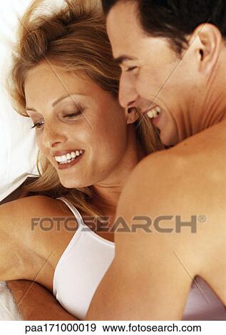Couple embracing in bed, head and shoulders, close-up View Large Photo Image Stock Photo - Couple embracing in bed, head and shoulders, close-up. Fotosearch